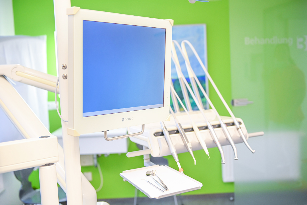 Ein weißer Monitor im Zusammenhang mit den verschiedenen zahnmedizinischen Kleingeräten des Zahnarztes in Flensburg.