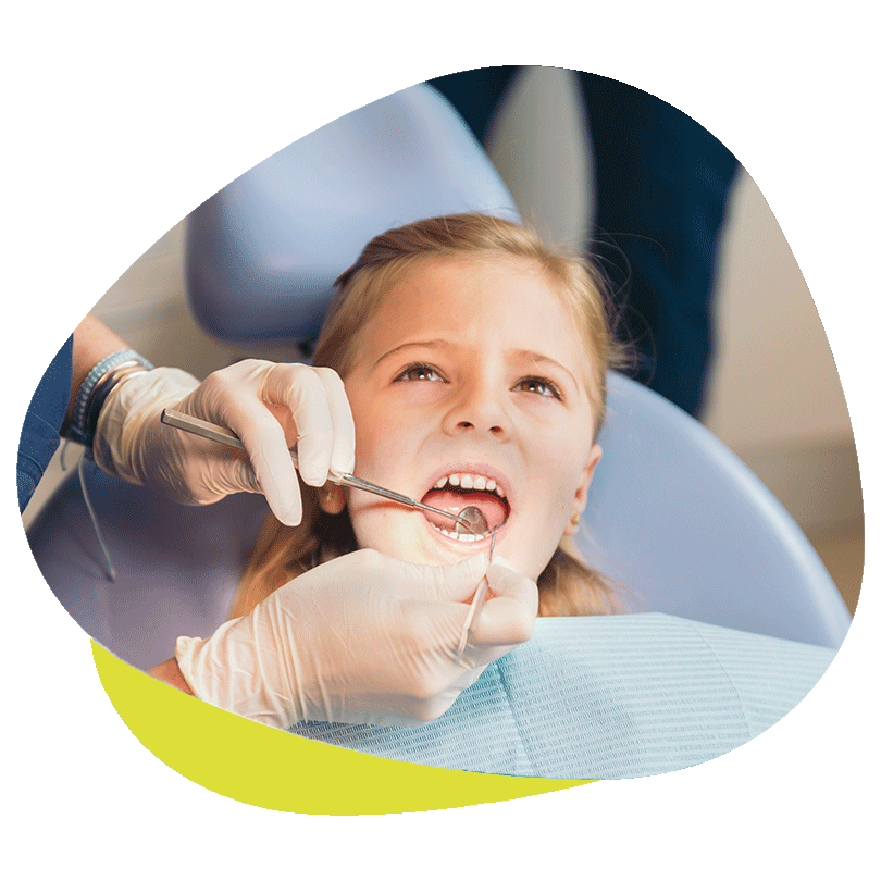 Ein Kinderzahnarzt führt eine Vorsorgeuntersuchung an den Zähnen eines Kindes durch.